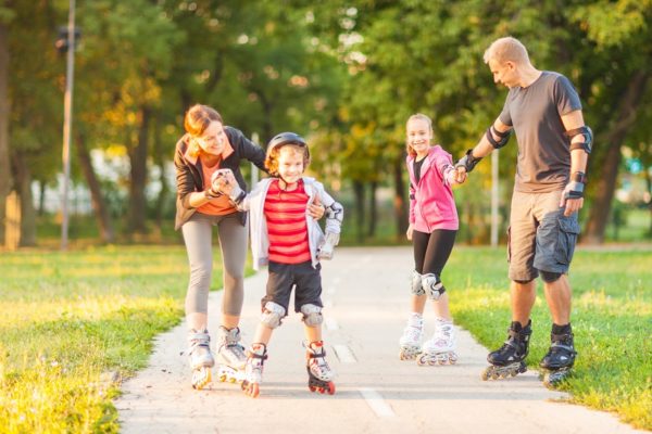 Family rollerblading in a park