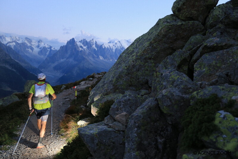 A man trail running in the night on a mountain top with a headtorch 